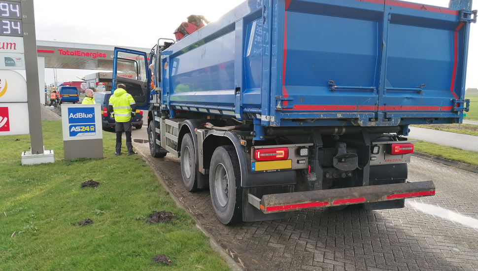 Toezichthouder en boa houden grondtransport aan om de lading en papieren te controleren.