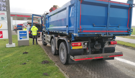 Toezichthouder en boa houden grondtransport aan om de lading en papieren te controleren. 
