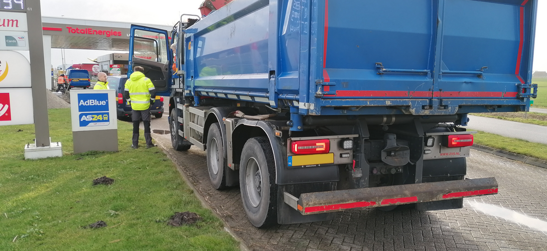 Toezichthouder en boa houden grondtransport aan om de lading en papieren te controleren. 