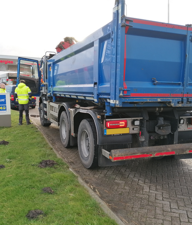 Toezichthouder en boa houden grondtransport aan om de lading en papieren te controleren. 